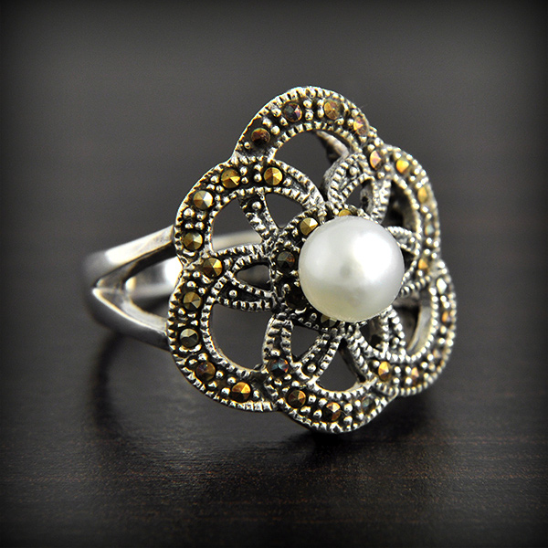 Très belle Bague en argent d'une fleur géométrique ajourée pavée de marcassites et surmontée...