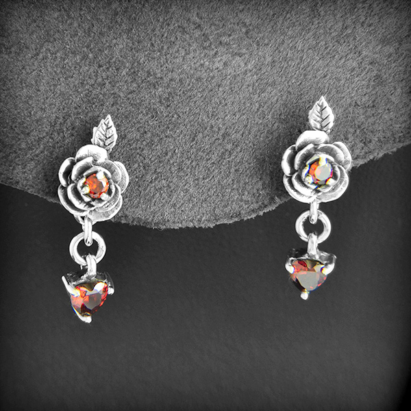 Boucles d'oreilles d'une magnifique petite rose en argent avec un petit zirconium au centre et un...