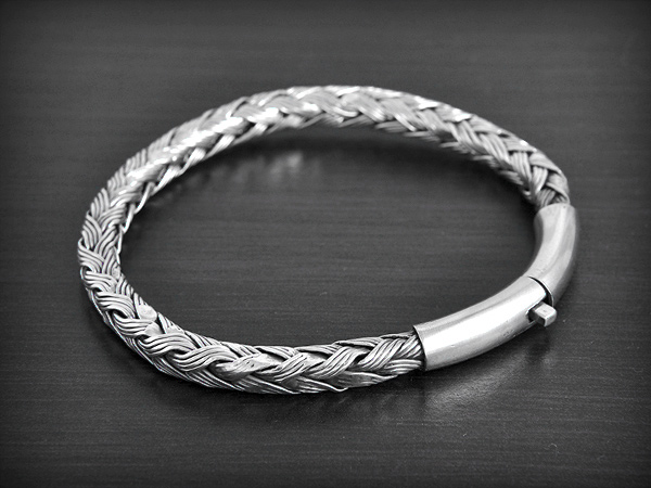 Très beau bracelet en argent semi-rigide avec une maille tressée et pourvu d'un fermoir sécurité...