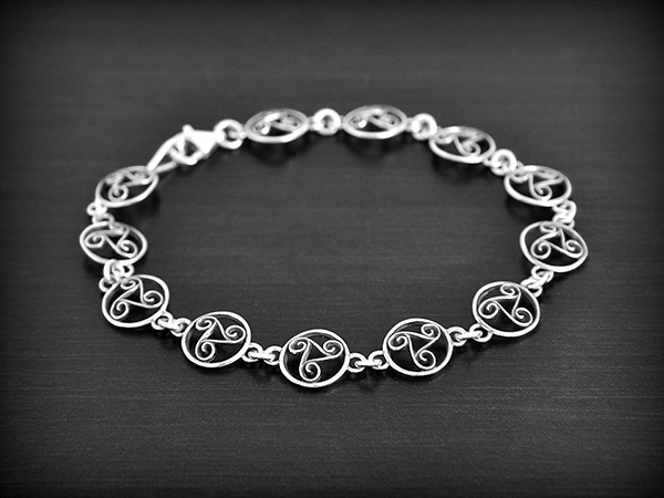 Bracelet celtique en argent avec 12 petits Triskels cerclés et ajourés et légèrement bombés...